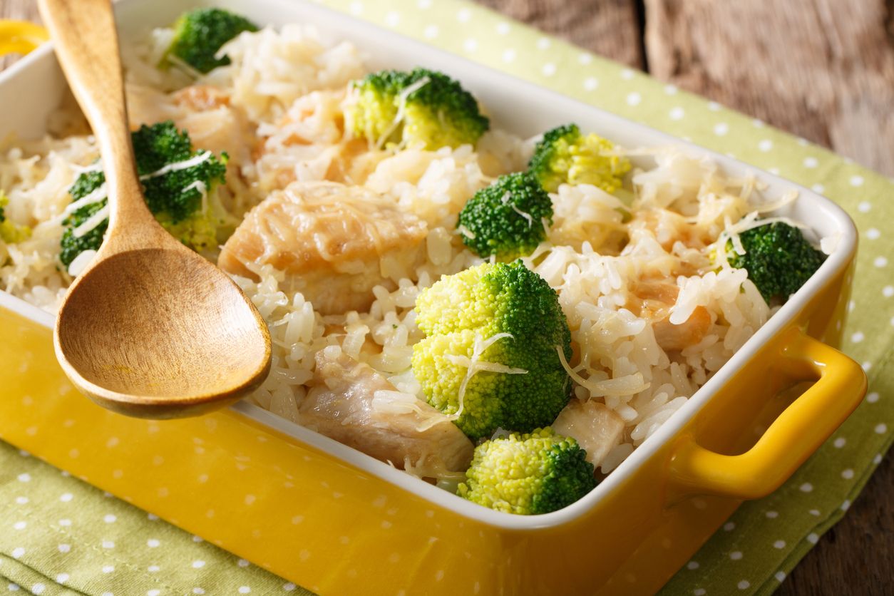 Homemade rice with broccoli, chicken, garlic and cheese close-up in a baking dish on a table. horizontal