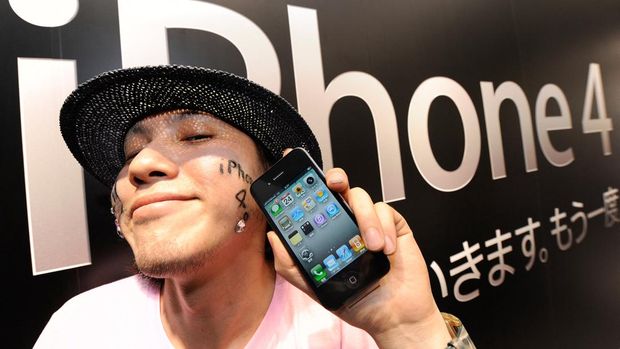 IPHONE 4 2010 A man holds his iPhone 4 in front of a mobile phone store in Tokyo on June 24, 2010. Hundreds of Apple fans braved sweltering humidity to form giant queues in an upscale Tokyo district in a race to be among the first in the world to get their hands on the latest iPhone. AFP PHOTO/Toru YAMANAKA (Photo by TORU YAMANAKA / AFP)