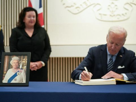 US President Joe Biden signs the condolence book at the British Embassy in Washington to pay his respects following the death of Britains Queen Elizabeth II as First Lady Jill Biden looks on in Washington, DC on September 8, 2022. (Photo by Mandel NGAN / AFP)