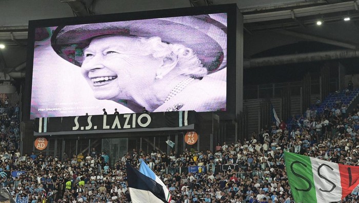 A portrait of Britain's Queen Elizabeth II is displayed on a giant screen following the announcement of her death, prior to the start of the UEFA Europa League Group F first leg football match between SS Lazio and Feyenoord Rotterdam at the Olympic stadium in Rome on September 8, 2022. (Photo by Vincenzo PINTO / AFP) (Photo by VINCENZO PINTO/AFP via Getty Images)