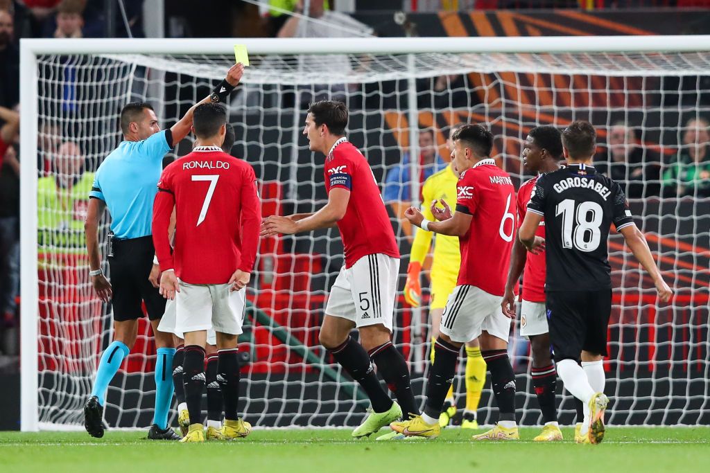 MANCHESTER, ENGLAND - SEPTEMBER 08: Lisandro Martinez of Manchester United is shown a yellow card by referee Marco Di Bello after Real Sociedad are awarded a penalty for handball during the UEFA Europa League group E match between Manchester United and Real Sociedad at Old Trafford on September 08, 2022 in Manchester, England. (Photo by Alex Livesey - Danehouse/Getty Images)