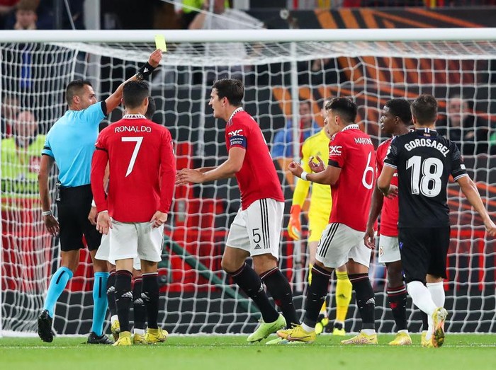 MANCHESTER, ENGLAND - SEPTEMBER 08: Lisandro Martinez of Manchester United is shown a yellow card by referee Marco Di Bello after Real Sociedad are awarded a penalty for handball during the UEFA Europa League group E match between Manchester United and Real Sociedad at Old Trafford on September 08, 2022 in Manchester, England. (Photo by Alex Livesey - Danehouse/Getty Images)