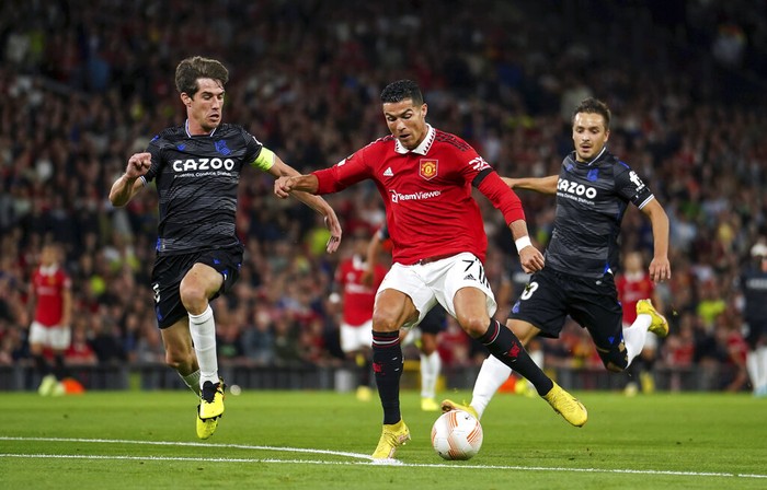 Manchester United vs Real Sociedad Real Sociedad's Aritz Elustondo, left, and Real Sociedad's Martin Zubimendi, right, challenge Manchester United's Cristiano Ronaldo during group E Europa League soccer match between Manchester United and Real Sociedad at Old Trafford in Manchester, England, Thursday, Sept. 8, 2022. (AP Photo/Dave Thompson)