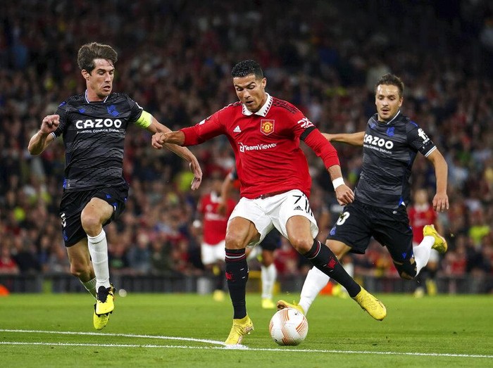 Real Sociedads Aritz Elustondo, left, and Real Sociedads Martin Zubimendi, right, challenge Manchester Uniteds Cristiano Ronaldo during group E Europa League soccer match between Manchester United and Real Sociedad at Old Trafford in Manchester, England, Thursday, Sept. 8, 2022. (AP Photo/Dave Thompson)