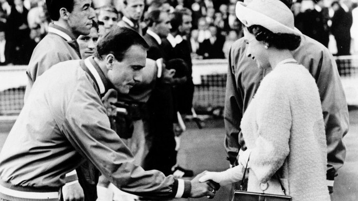 English defender George Cohen, with teammate goalkeeper Gordon Banks standing next to him, bows his head as he shakes hand with Queen Elizabeth II of England 11 July 1966 at Wembley stadium in London before the start of the World Cup opening match between the host country and Uruguay. (Photo by STAFF / AFP) (Photo by STAFF/AFP via Getty Images)