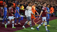 Para pemain juga mengenakan ban hitam di lengan sebagai tanda duka cita untuk Ratu Elizabeth II. Tampak skuad West Ham United dan FCSB memasuki lapangan Stadion Olimpiade London. (Foto: Getty Images/Richard Heathcote)