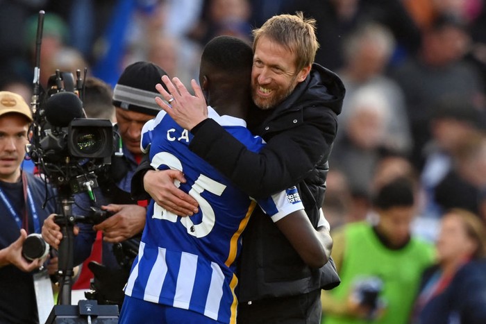 Brightons English manager Graham Potter (R) embraces Brightons Ecuadorian midfielder Moises Caicedo on the pitch after the English Premier League football match between Brighton and Hove Albion and Manchester United at the American Express Community Stadium in Brighton, southern England on May 7, 2022. - Brighton won the game 4-0. - RESTRICTED TO EDITORIAL USE. No use with unauthorized audio, video, data, fixture lists, club/league logos or live services. Online in-match use limited to 120 images. An additional 40 images may be used in extra time. No video emulation. Social media in-match use limited to 120 images. An additional 40 images may be used in extra time. No use in betting publications, games or single club/league/player publications. (Photo by Glyn KIRK / AFP) / RESTRICTED TO EDITORIAL USE. No use with unauthorized audio, video, data, fixture lists, club/league logos or live services. Online in-match use limited to 120 images. An additional 40 images may be used in extra time. No video emulation. Social media in-match use limited to 120 images. An additional 40 images may be used in extra time. No use in betting publications, games or single club/league/player publications. / RESTRICTED TO EDITORIAL USE. No use with unauthorized audio, video, data, fixture lists, club/league logos or live services. Online in-match use limited to 120 images. An additional 40 images may be used in extra time. No video emulation. Social media in-match use limited to 120 images. An additional 40 images may be used in extra time. No use in betting publications, games or single club/league/player publications. (Photo by GLYN KIRK/AFP via Getty Images)