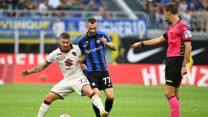 Torinos Polish midfielder Karol Linetta (L) fights for the ball with Inter Milans Croatian midfielder Marcelo Brozovic (C) as referee Giovanni Ayroldi gestures (R) during the Italian Serie A football match between Inter Milan and Torino at the San Siro stadium in Milan, on September 10, 2022. (Photo by Isabella BONOTTO / AFP) (Photo by ISABELLA BONOTTO/AFP via Getty Images)
