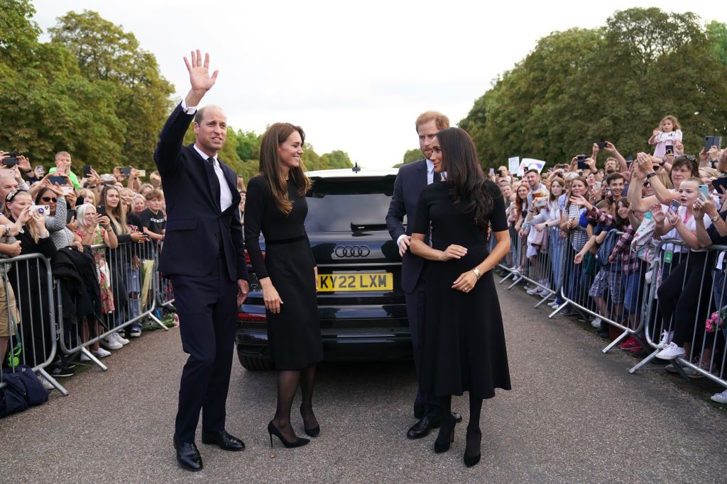 1422564352 WINDSOR, ENGLAND - SEPTEMBER 10: Prince Harry, Duke of Sussex, Meghan, Duchess of Sussex, Prince William, Prince of Wales and Catherine, Princess of Wales look at floral tributes laid by members of the public on the Long walk at Windsor Castle on September 10, 2022 in Windsor, England. Crowds have gathered and tributes left at the gates of Windsor Castle to Queen Elizabeth II, who died at Balmoral Castle on 8 September, 2022. (Photo by Chris Jackson - WPA Pool/Getty Images)