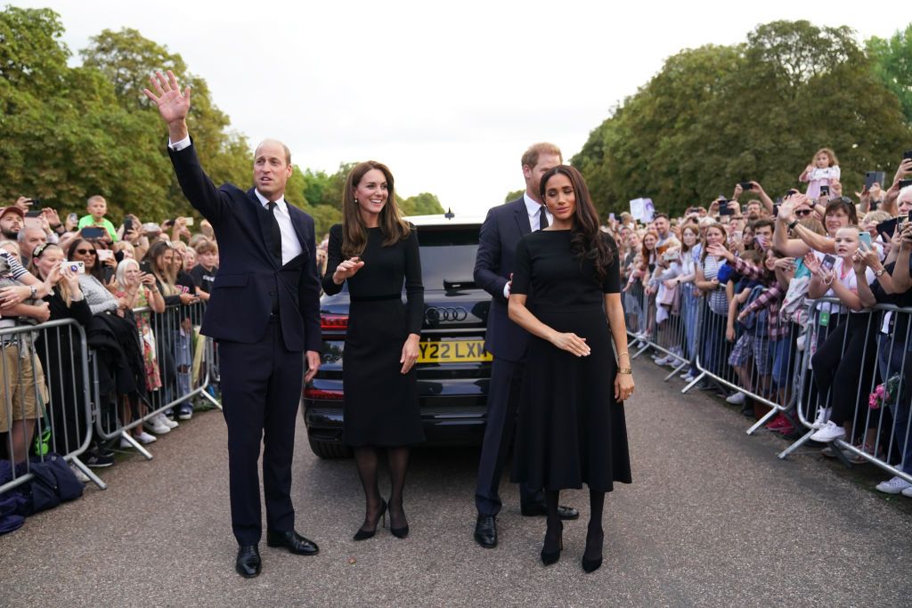 WINDSOR, ENGLAND - SEPTEMBER 10: Prince Harry, Duke of Sussex, Meghan, Duchess of Sussex, Prince William, Prince of Wales and Catherine, Princess of Wales look at floral tributes laid by members of the public on the Long walk at Windsor Castle on September 10, 2022 in Windsor, England. Crowds have gathered and tributes left at the gates of Windsor Castle to Queen Elizabeth II, who died at Balmoral Castle on 8 September, 2022. (Photo by Chris Jackson - WPA Pool/Getty Images)