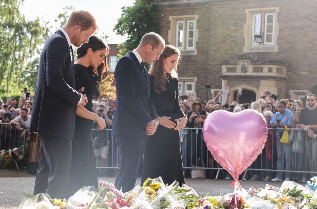 1422564352 WINDSOR, ENGLAND - SEPTEMBER 10: Prince Harry, Duke of Sussex, Meghan, Duchess of Sussex, Prince William, Prince of Wales and Catherine, Princess of Wales look at floral tributes laid by members of the public on the Long walk at Windsor Castle on September 10, 2022 in Windsor, England. Crowds have gathered and tributes left at the gates of Windsor Castle to Queen Elizabeth II, who died at Balmoral Castle on 8 September, 2022. (Photo by Chris Jackson - WPA Pool/Getty Images)