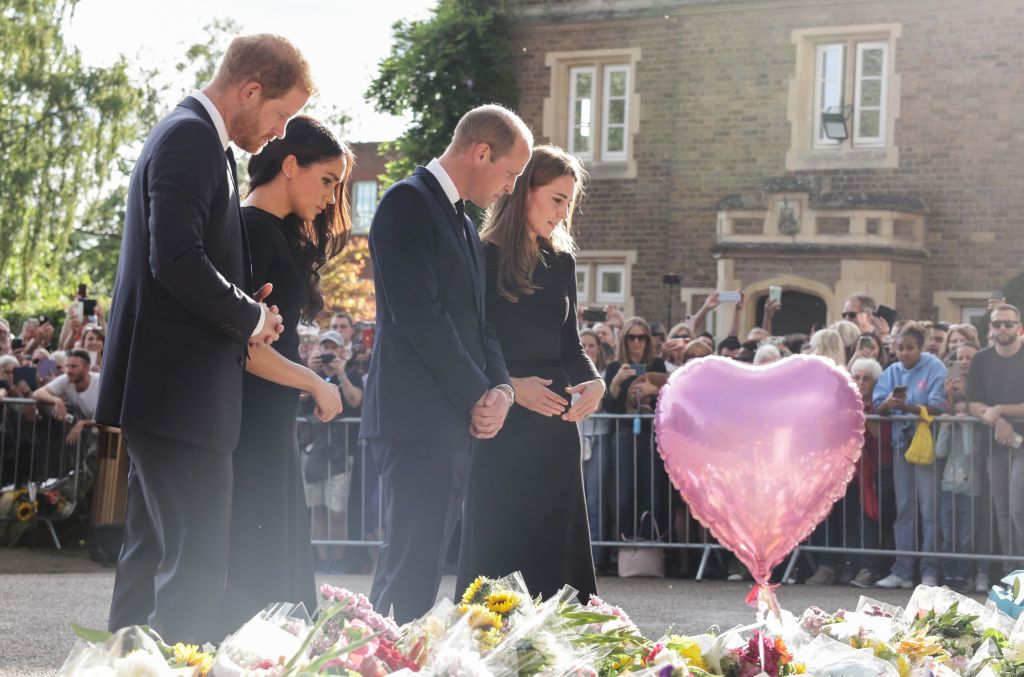 WINDSOR, ENGLAND - SEPTEMBER 10: Prince Harry, Duke of Sussex, Meghan, Duchess of Sussex, Prince William, Prince of Wales and Catherine, Princess of Wales look at floral tributes laid by members of the public on the Long walk at Windsor Castle on September 10, 2022 in Windsor, England. Crowds have gathered and tributes left at the gates of Windsor Castle to Queen Elizabeth II, who died at Balmoral Castle on 8 September, 2022. (Photo by Chris Jackson - WPA Pool/Getty Images)