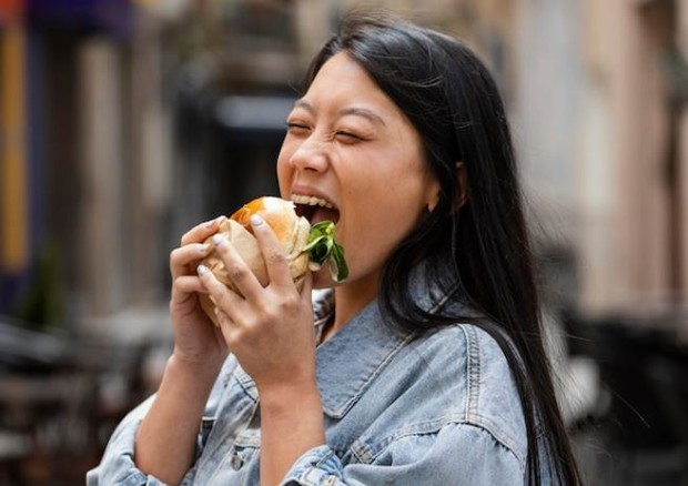 wanita memakan burger