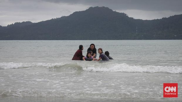 PANTAI NATSEPA AMBON Aktifitas wisatawan lokal dan pemandangan pantai saat musim hujan di Pantai Natsepa, Maluku Tengah, Selasa, 12 Juli 2022. Pantai Natsepa memiliki pasir putih dan salah satu yang terluas di sepanjang pesisir pulau Ambon. CNN Indonesia/Safir Makki