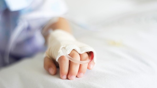 Saline intravenous (iv) drip in a Childrens patient hand