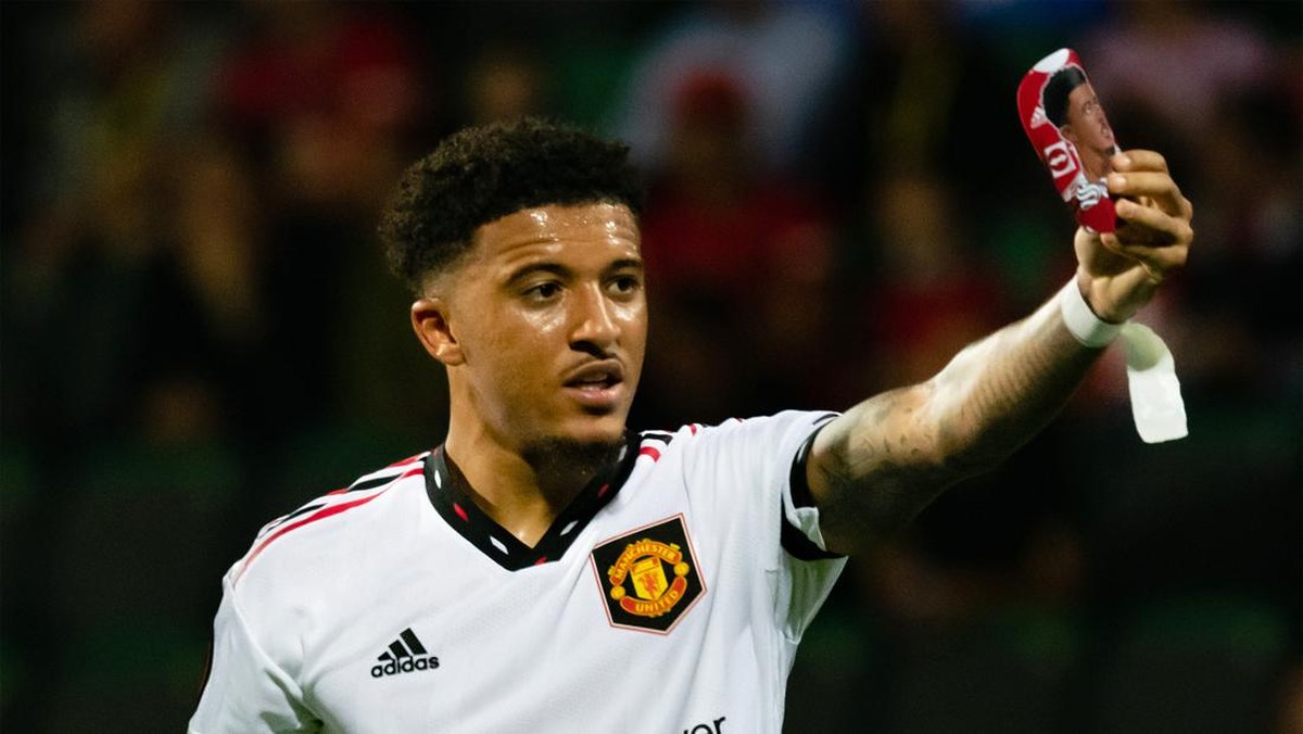 Jadon Sancho memamerkan deker pemberian fans cilik. (Foto: Manchester United via Getty Imag/Ash Donelon)