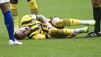 Reus terkapar usai kena tekel pemain Schalke yang dihadapi timnya, Dortmund, pada akhir pekan. Foto: AP/Bernd Thissen