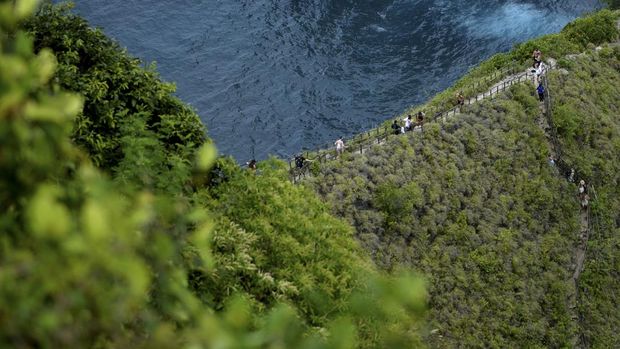 Wisatawan mengunjungi Pantai Kelingking di Nusa Penida, Klungkung, Bali, Sabtu (17/9/2022). Kunjungan wisatawan ke Nusa Penida yang merupakan salah satu destinasi pariwisata unggulan di Bali itu saat ini terus meningkat dengan rata-rata kunjungan 2.000 hingga 3.000 orang wisatawan per hari. ANTARA FOTO/Fikri Yusuf/aww.