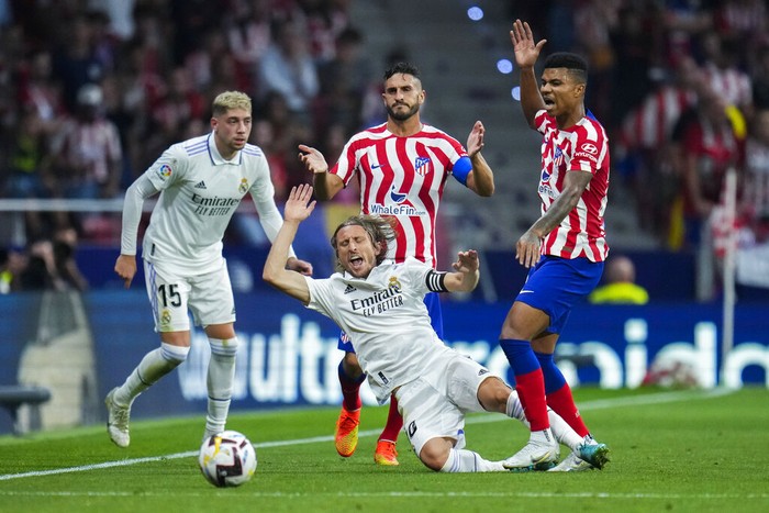 Atletico Madrids Marcos Llorente, left, tussles for the ball with Real Madrids Ferland Mendy during the Spanish La Liga soccer match between Atletico Madrid and Real Madrid at the Wanda Metropolitano stadium in Madrid, Spain, Sunday, Sept. 18, 2022. Real Madrid won 2-1. (AP Photo/Manu Fernandez)