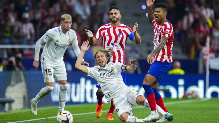 Derby Ibu Kota, Real Madrid Bungkam Atletico 2-1 Atletico Madrid's Marcos Llorente, left, tussles for the ball with Real Madrid's Ferland Mendy during the Spanish La Liga soccer match between Atletico Madrid and Real Madrid at the Wanda Metropolitano stadium in Madrid, Spain, Sunday, Sept. 18, 2022. Real Madrid won 2-1. (AP Photo/Manu Fernandez)