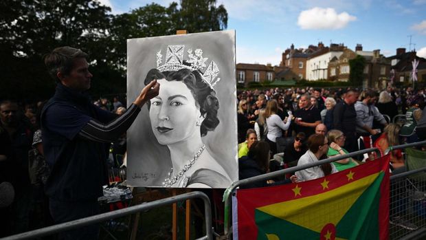 An artist displays s drawing on The Long Walk in Windsor on September 19, 2022, waiting for the coffin of the late Queen Elizabeth II to make its final journey to Windsor Castle after the State Funeral Service of Britain's Queen Elizabeth II. (Photo by CARL DE SOUZA / POOL / AFP)