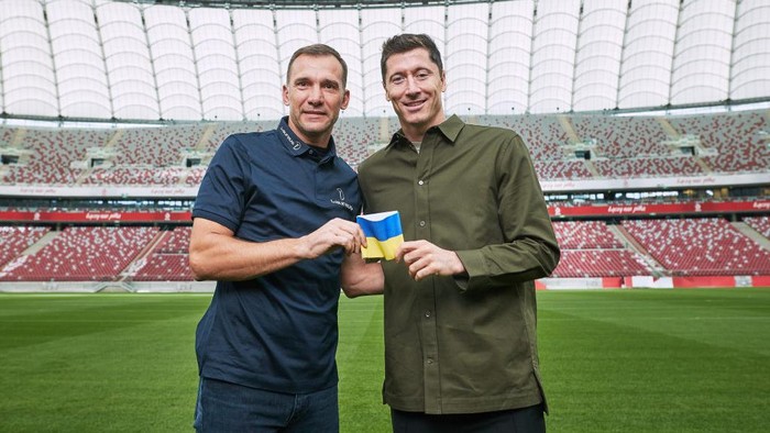 WARSAW, POLAND - SEPTEMBER 20: Poland captain Robert Lewandowski receives a Ukraine armband from Laureus Ambassador Andriy Shevchenko and pledges to carry it to FIFA World Cup 2022 Qatar at PGE Narodowy Stadium on September 20, 2022 in Warsaw, Poland. (Photo by Joosep Martinson/Getty Images for Laureus)