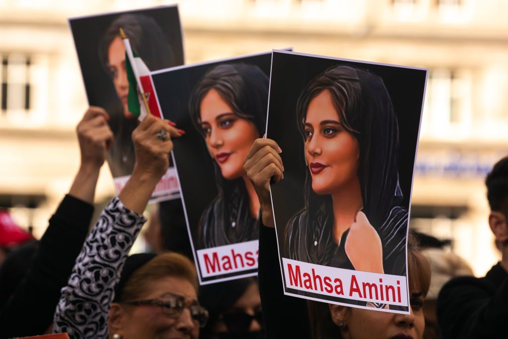 Signs of  picture of Mahsa Amini  are seen  in front of Dom Cathedral in Cologne, Germany on September 21, 2022 to protest against woman's death in the custody which sparked outrage against government in Iran (Photo by Ying Tang/NurPhoto via Getty Images)