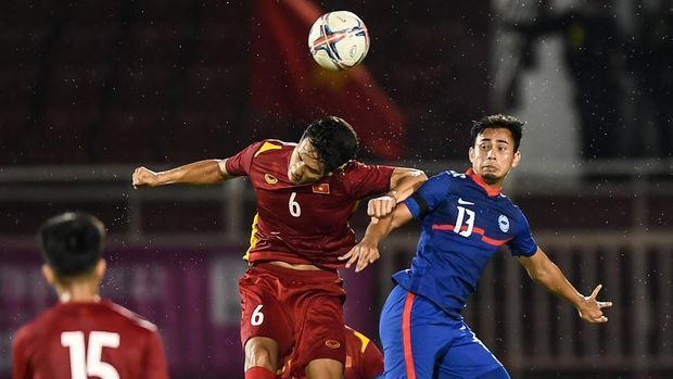 Vietnam vs Singapura Vietnam's Luong Duy Cuong (C) and Singapore's Adam Swandi (R) fight for the ball in the air during the Hung Thinh International Football Tournament 2022 friendly football match between Vietnam and Singapore at Thong Nhat Stadium in Ho Chi Minh City, on September 21, 2022. (Photo by Nhac NGUYEN / AFP)
