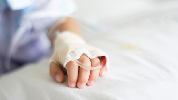 Saline intravenous (iv) drip in a Children's patient hand