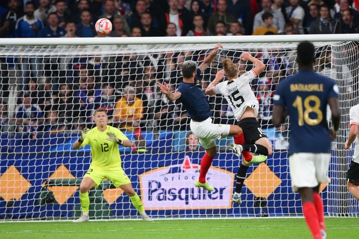 Frances forward Olivier Giroud (C) heads the ball past Austrias defender Philipp Lienhart (C/R) during the UEFA Nations League, League A Group 1 football match between France and Austria at Stade de France in Saint-Denis, north of Paris, on September 22, 2022. (Photo by Anne-Christine POUJOULAT / AFP) (Photo by ANNE-CHRISTINE POUJOULAT/AFP via Getty Images)
