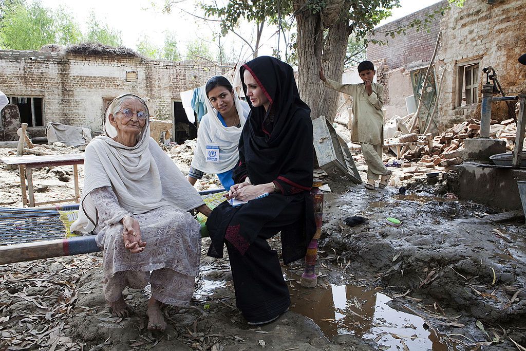This handout photo released by the UN High Commission for Refugees (UNHCR) shows US actress and UNHCR Goodwill Ambassador Angelina Jolie (R) meeting with 64-year-old Zenul Hawa, a flood affected victim, in the village of Mohib Bandi, on the outskirts of Nowshera, on September 7, 2010. Hollywood actress Angelina Jolie has visited Pakistan's northwest to draw the world's attention towards the plight of 21 million people affected by the country's worst-ever floods. AFP PHOTO/UNHCR/JASON TANNER -- RESTRICTED TO EDITORIAL USE- NOT FOR MARKETING OR ADVERTISING CAMPAIGNS-MANDATORY CREDIT (Photo credit should read JASON TANNER/AFP via Getty Images)