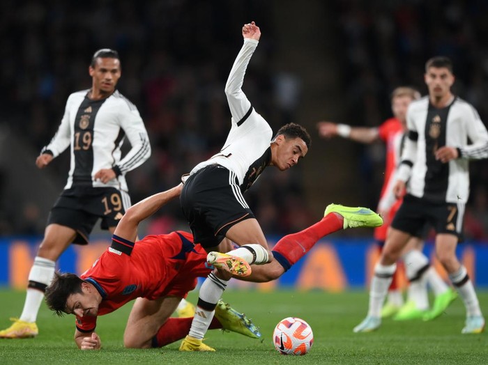 LONDON, ENGLAND - SEPTEMBER 26: Harry Maguire of England is tackled by Jamal Musiala of Germany during the UEFA Nations League League A Group 3 match between England and Germany at Wembley Stadium on September 26, 2022 in London, England. (Photo by Shaun Botterill/Getty Images)