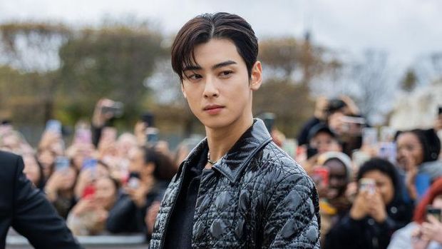 PARIS, FRANCE - SEPTEMBER 27: Cha Eun-woo wears black varnished coat, pants outside Dior during Paris Fashion Week - Womenswear Spring/Summer 2023 : Day Two on September 27, 2022 in Paris, France. (Photo by Christian Vierig/Getty Images)