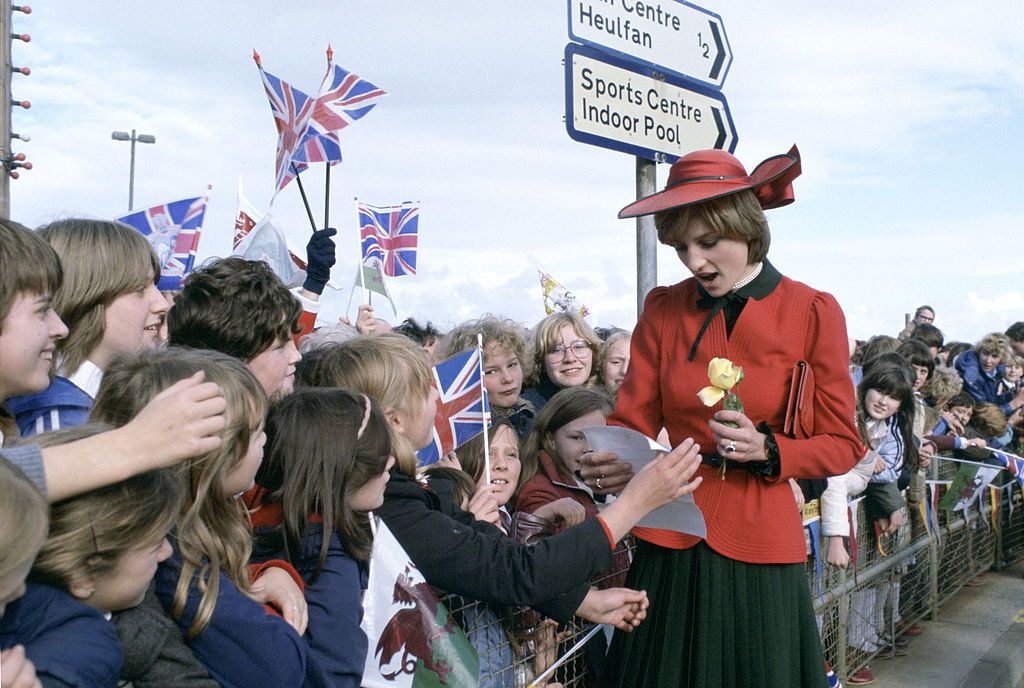 RHYL, UNITED KINGDOM - OCTOBER 27:  Princess Diana In Rhyl On Her First Official Visit To Wales Is Greeted By A Huge Crowd Waving Union Jack Flags. Some Of The Children Wrote Notes And Poems Which She Read.her Outfit Designed By Donald Campbell  (Photo by Tim Graham Photo Library via Getty Images)
