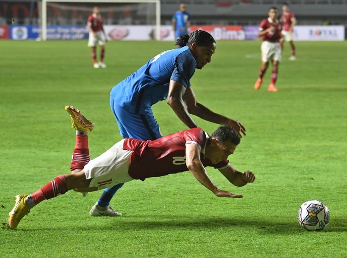 Pesepak bola Tim Nasional Indonesia Egy Maulana Vikri (bawah) terjatuh usai berebut bola dengan pesepak bola Tim Nasional Curacao Shermaine Martina (atas) dalam pertandingan 'FIFA Match Day' di Stadion Pakansari, Cibinong, Kabupaten Bogor, Jawa Barat, Selasa (27/9/2022). ANTARA FOTO/Aditya Pradana Putra/hp.