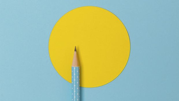 Top view of turquoise polka dot pencil on colorful paper combine with yellow circle. Minimalist template with copy space.