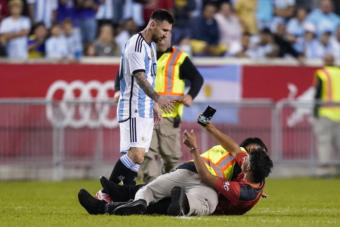Lionel Messi, A fan is tackled as he tries to take a picture of Argentina's player Lionel Messi during the second half of an international friendly soccer match against Jamaica on Tuesday, Sept. 27, 2022, in Harrison, N.J. (AP Photo/Eduardo Munoz Alvarez)