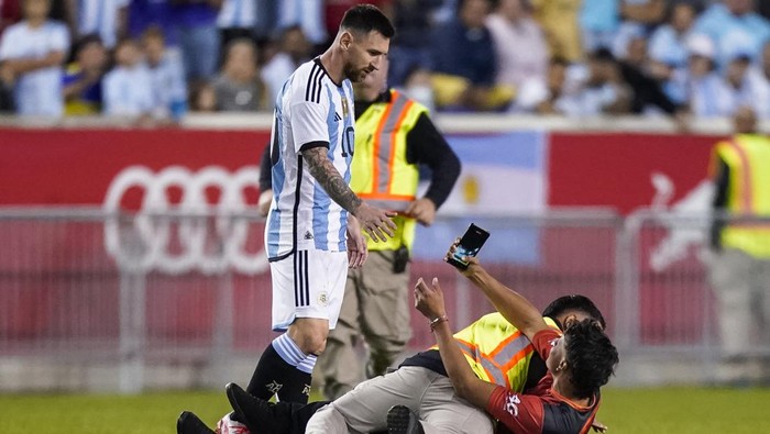A fan is tackled as he tries to take a picture of Argentinas player Lionel Messi during the second half of an international friendly soccer match against Jamaica on Tuesday, Sept. 27, 2022, in Harrison, N.J. (AP Photo/Eduardo Munoz Alvarez)