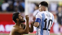 Suporter lainnya masuk ke lapangan tepat setelah Messi mencetak gol pada menit ke-86. Aksinya sempat bikin Messi terkejut, lihat tuh gesturenya.(Foto: AFP via Getty Images/ANDRES KUDACKI)