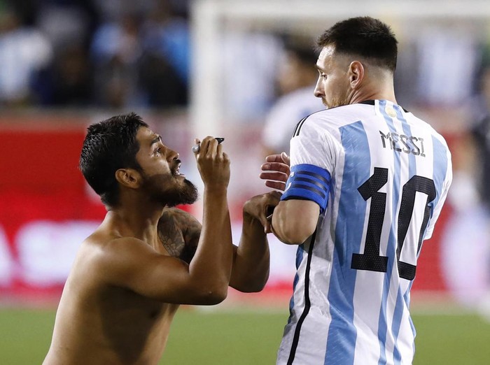 Argentina's Lionel Messi reacts as a fan ran on the pitch to ask for his autograh during the international friendly football match between Argentina and Jamaica at Red Bull Arena in Harrison, New Jersey, on September 27, 2022. (Photo by Andres Kudacki / AFP) (Photo by ANDRES KUDACKI/AFP via Getty Images)