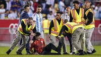 Tapi belum sempat ia berinteraksi dengan Messi, petugas langsung merobohkan dan mengamankannya. Kejadian ini berlangsung bahkan saat Messi belum mencetak gol buat Argentina. (Foto: AP/Eduardo Munoz Alvarez)