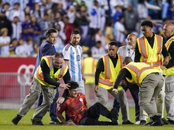 Tapi belum sempat ia berinteraksi dengan Messi, petugas langsung merobohkan dan mengamankannya. Kejadian ini berlangsung bahkan saat Messi belum mencetak gol buat Argentina. (Foto: AP/Eduardo Munoz Alvarez)