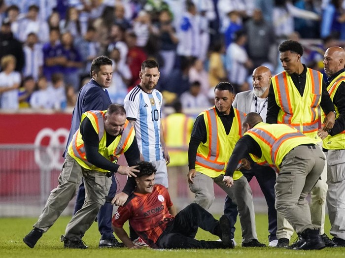 A fan is tackled as he tried to take a picture of Argentina's player Lionel Messi during the second half of an international friendly soccer match against Jamaica on Tuesday, Sept. 27, 2022, in Harrison, N.J. (AP Photo/Eduardo Munoz Alvarez)