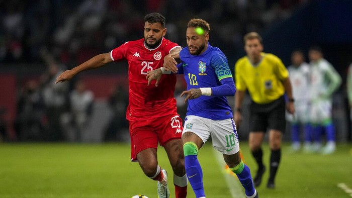 Neymar, Brasil Vs Tunisia Brazil's Neymar has a laser light on his face as he duels for the ball with Tunisia's Anis Ben Slimane during the international friendly soccer match between Brazil and Tunisia at the Parc des Princes stadium in Paris, France, Tuesday, Sept. 27, 2022. (AP Photo/Christophe Ena)