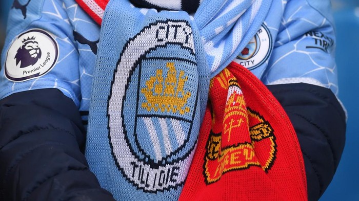 MANCHESTER, ENGLAND - MARCH 06: A young fan is seen wearing a half and half scarf inside the stadium prior to the Premier League match between Manchester City and Manchester United at Etihad Stadium on March 06, 2022 in Manchester, England. (Photo by Laurence Griffiths/Getty Images)