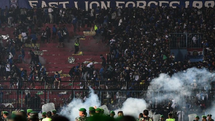 Foto-foto Kerusuhan di Stadion Kanjuruhan, 127 Orang Tewas This picture taken on October 1, 2022 shows security personnel (lower) on the pitch after a football match between Arema FC and Persebaya Surabaya at Kanjuruhan stadium in Malang, East Java. - At least 127 people died at a football stadium in Indonesia late on October 1 when fans invaded the pitch and police responded with tear gas, triggering a stampede, officials said. (Photo by AFP) (Photo by STR/AFP via Getty Images)