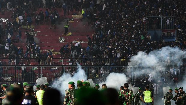 This picture taken on October 1, 2022 shows security personnel (lower) on the pitch after a football match between Arema FC and Persebaya Surabaya at Kanjuruhan stadium in Malang, East Java. - At least 127 people died at a football stadium in Indonesia late on October 1 when fans invaded the pitch and police responded with tear gas, triggering a stampede, officials said. (Photo by AFP)