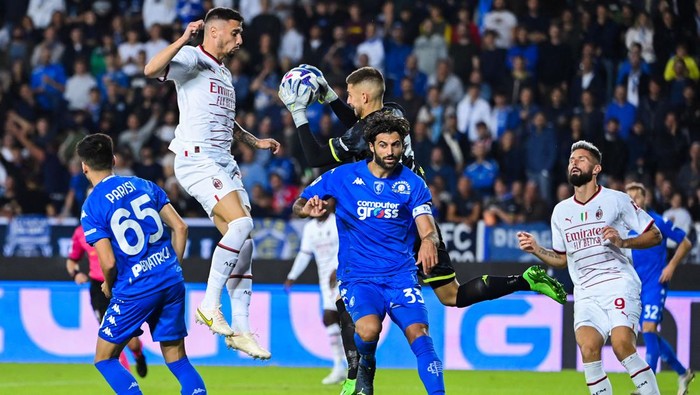 Empolis Italian goalkeeper Guglielmo Vicario (Rear C) grabs the ball ahead of AC Milans Algerian defender Ismael Bennacer during the Italian Serie A football math between Empoli and AC Milan on October 1, 2022 at the Carlo-Castellani stadium in Empoli. (Photo by Alberto PIZZOLI / AFP) (Photo by ALBERTO PIZZOLI/AFP via Getty Images)