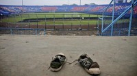 Sepasang sepatu milik suporter Arema tertinggal di tribun stadion usai kerusuhan. Tribun 12 jadi salah satu saksi bisu mencekam Tragedi Kanjuruhan setelah laga Arema FC vs Persebaya. (AP Photo/Hendra Permana)