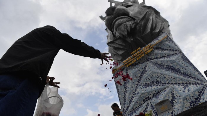 Suporter Arema FC  (Aremania) menabur bunga di Patung Singa Stadion Kanjuruhan, Malang, jawa Timur, Minggu (2/10/2022). Sejumlah suporter Arema menabur bunga di Stadion Kanjuruhan sebagai bentuk duka cita atas jatuhnya korban dalam kerusuhan yang terjadi di stadion itu. ANTARA FOTO/Zabur Karuru/foc.